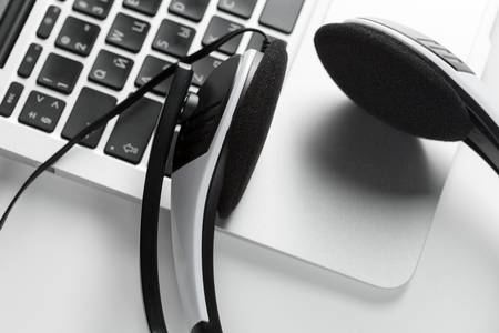 call center support concept. headset on keyboard computer laptopの写真素材