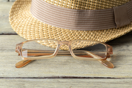 hat and eyeglasses on wooden tableの写真素材