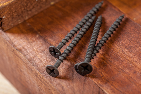 screws on a wooden tableの写真素材