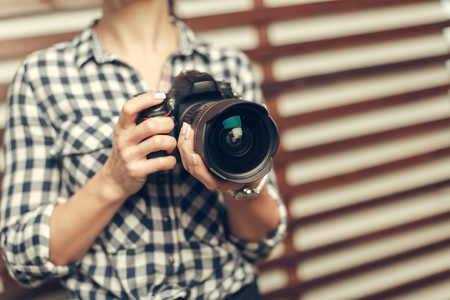 Pretty woman is a professional photographer with dslr cameraの写真素材