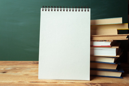 Classroom with blackboard, wooden table and books