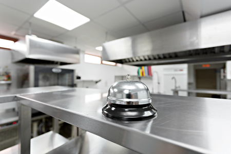 Alert bell on kitchen table in a restaurantの写真素材