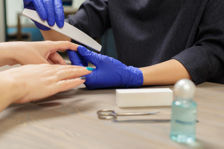 Woman hands receiving a manicure in beauty salonの写真素材