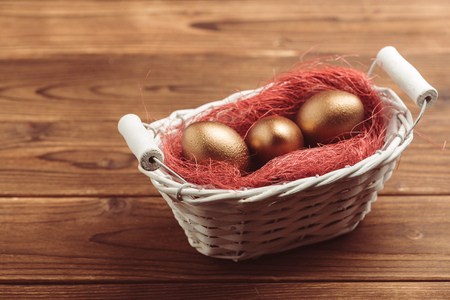 gold eggs on wooden tableの写真素材