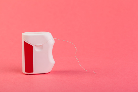 Dental floss on color background