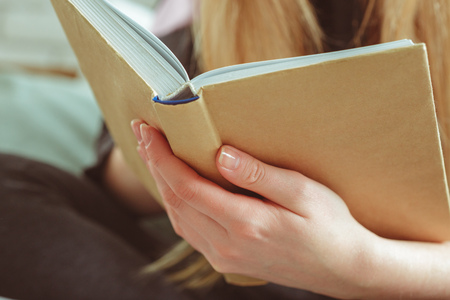 Woman reading book in roomの写真素材