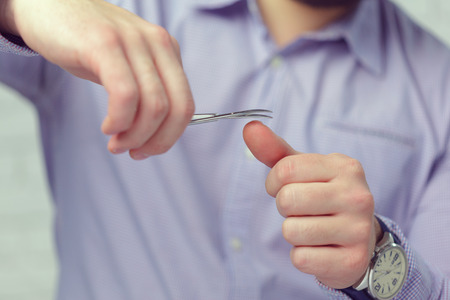 young man polishing his nailsの写真素材