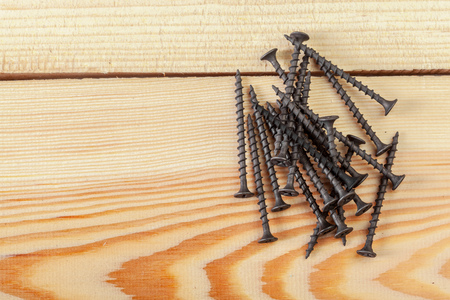 screws on a wooden tableの写真素材