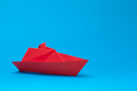 Origami paper boat on blue backgroundの写真素材