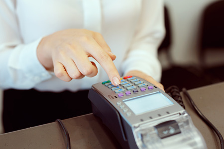 Guest at hotel reception paying with check during check-in