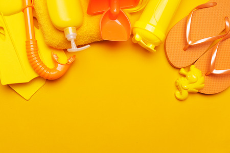 Composition of beachwear and accessories on a yellow background