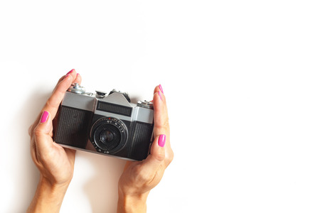 female hands hold vintage camera on white backgroundの写真素材