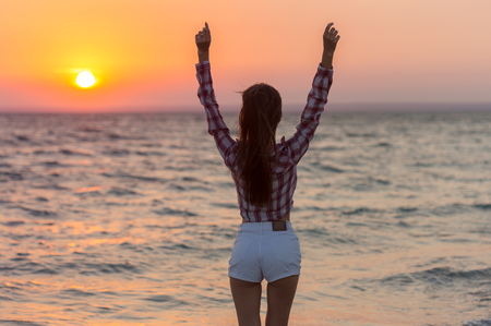 Happy carefree woman on the beach enjoying summerの写真素材