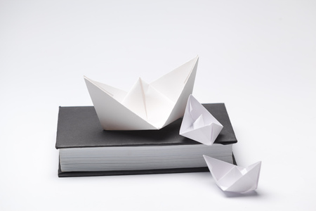 Origami paper boat on a book