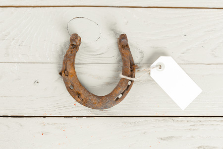 old rusty horseshoes on wooden boardの写真素材