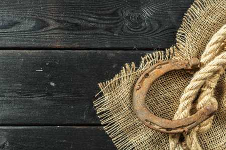 Old horseshoe and rope on wooden boardsの写真素材