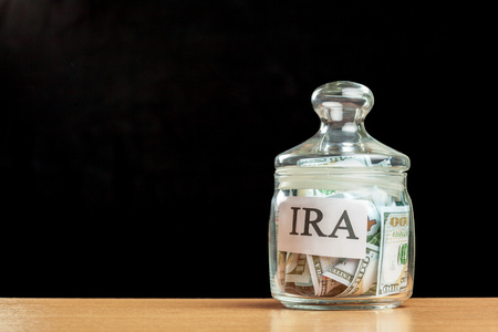 glass jar used for saving US dollar bills and notes for IRA retirement fundの写真素材