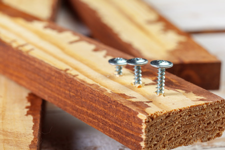 screw screwed into a wooden barの写真素材