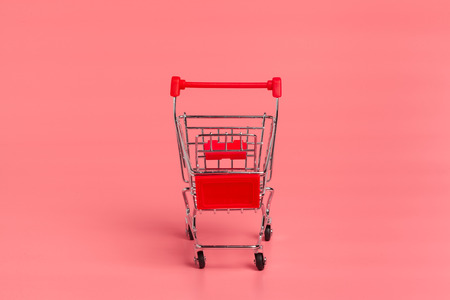 Shopping cart or supermarket trolley on pink backgroundの写真素材