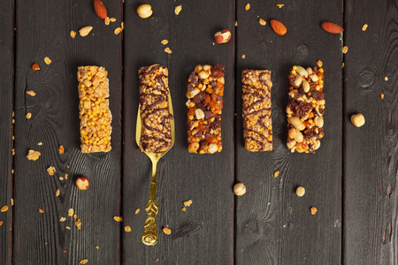 Healthy bars with nuts, seeds and dried fruits on the wooden table