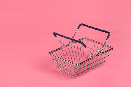 Shopping cart or supermarket trolley on pink background