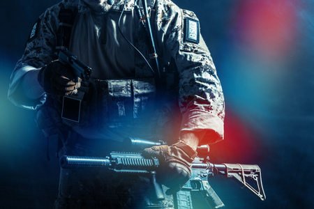 Special forces soldier with rifle on dark background