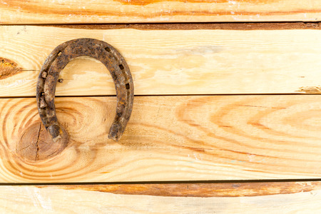 old rusty horseshoes on wooden board