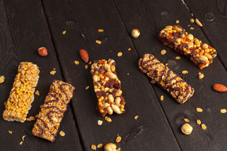 Healthy bars with nuts, seeds and dried fruits on the wooden table