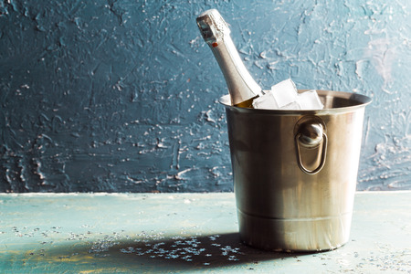 Champagne bottle in bucket with ice and glasses of champagneの写真素材
