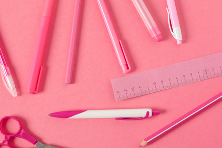 On a pink background, school accessories and a pen, colored pencilsの写真素材