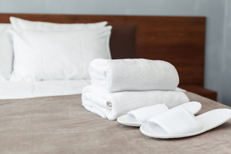 White towel on bed in guest room for hotel customerの写真素材