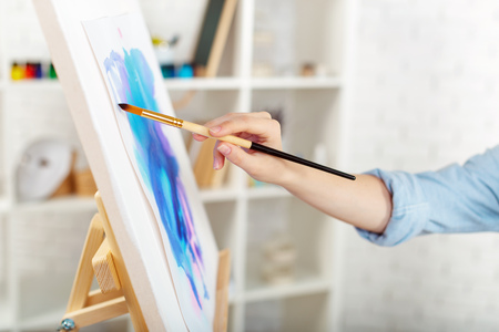 Young female artist painting picture in studioの写真素材