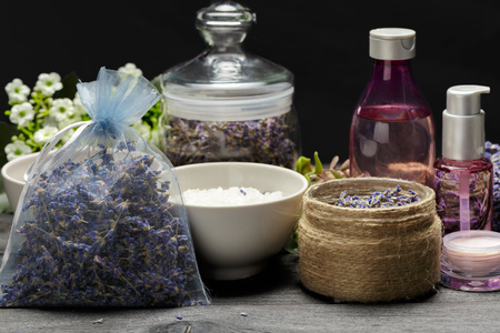 Aromatic composition of lavender, herbs, cosmetics and salt on a dark table topの写真素材