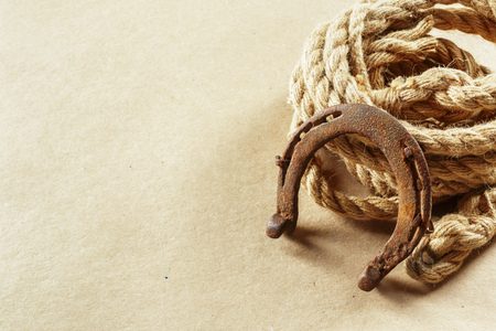 Old horseshoe and rope on wooden boardsの写真素材
