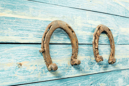old rusty horseshoes on wooden boardの写真素材