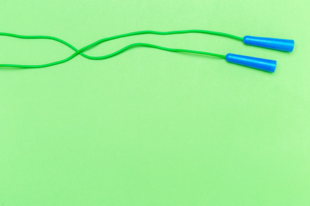 Green rubber jumping rope with blue handles top viewの写真素材