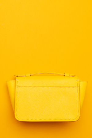 Small women handbag on bright yellow background top viewの写真素材