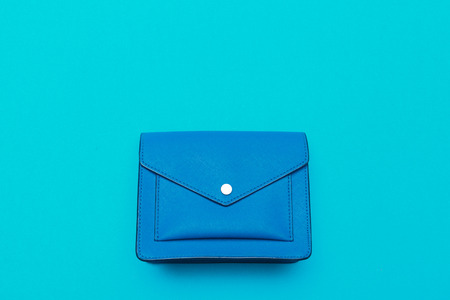 Small women handbag on bright blue background top viewの写真素材