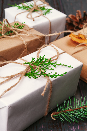 Christmas composition. Christmas gift, knitted blanket, pine cones, fir branches on wooden background.の写真素材