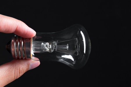 A classic Edison light bulb on dark background with space for textの写真素材