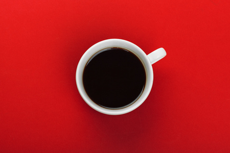 Coffee cup with coffee beans on red background.の写真素材