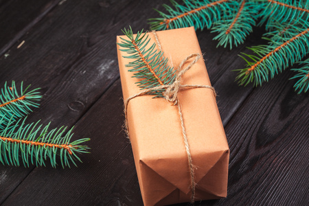 Christmas gift boxes and fir tree branch on wooden table.