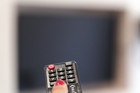 Watching TV and using remote controllerの写真素材