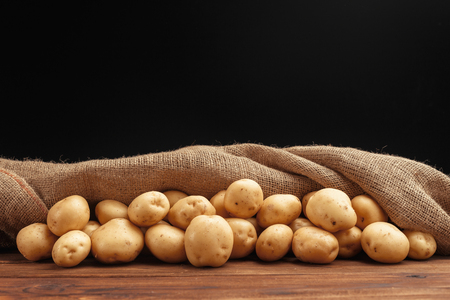 Pile of potatoes lying on wooden boardsの写真素材