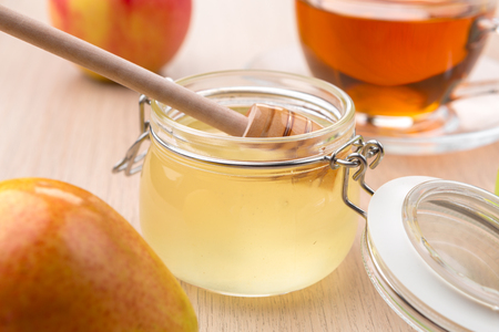 Jewish holiday Rosh Hashanah background with honey and apples on wooden table.の写真素材