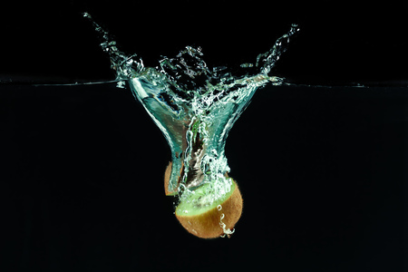 Splashing kiwi fruit on the waterの写真素材