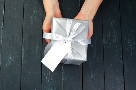 gift box in hand girls on wood tableの写真素材
