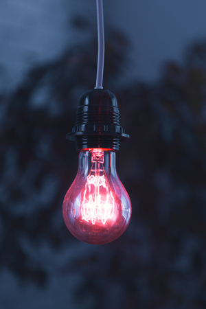 A classic Edison light bulb on dark background with space for text