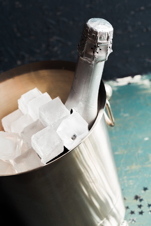 Champagne bottle in bucket with ice and glasses of champagneの写真素材