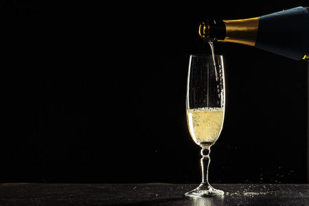 bottle of champagne and glasses over dark backgroundの写真素材